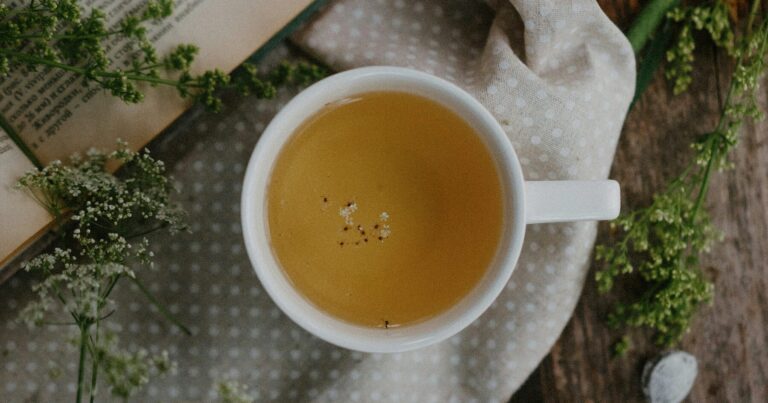 A cup of herbal tea photographed from above on a wooden table