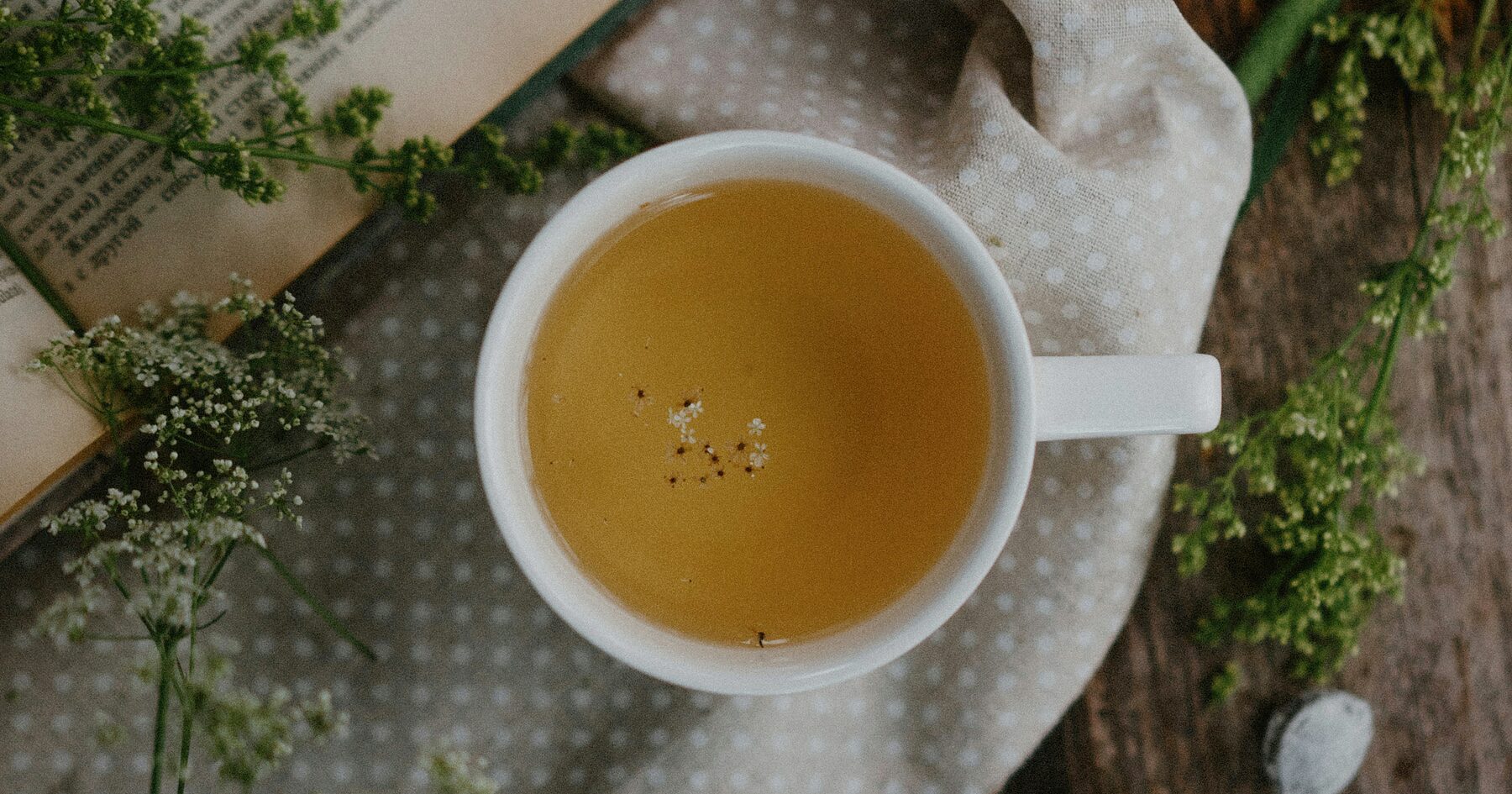 A cup of herbal tea photographed from above on a wooden table